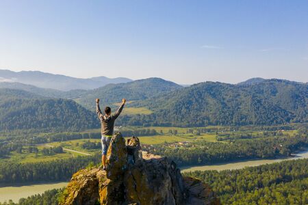 Man standing with raised hands on the top of Mountain Devils finger peak. Altaiの写真素材