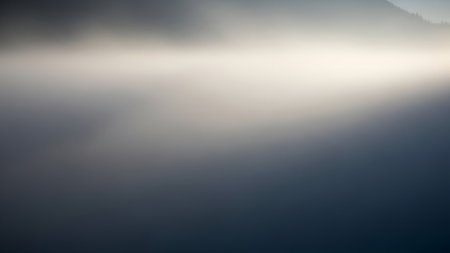 A soft, luminous beam of light cuts across a dark, textured abstract background, creating a sense of mystery and depth.の素材