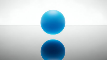 A single, vibrant blue sphere is perfectly centered, levitating above its own reflection on a glossy surface against a clean, white background.の素材