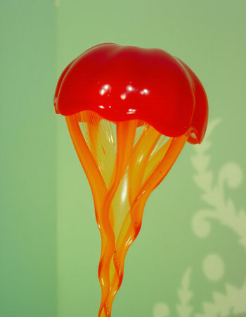 A red jellyfish floating on a green background with snowflakesの写真素材