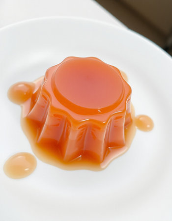 Pudding with caramel on a white plate, close-up.の写真素材