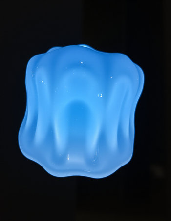 Blue light bulb on a black background, closeup of photo.