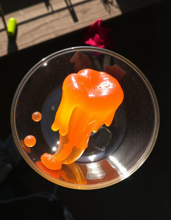Orange jelly candies in a glass bowl on a black backgroundの写真素材