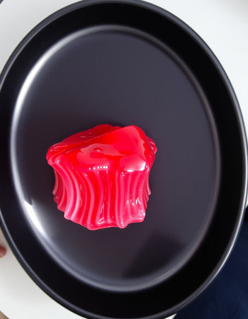 Red jelly cake in a black plate on white background, top viewの写真素材