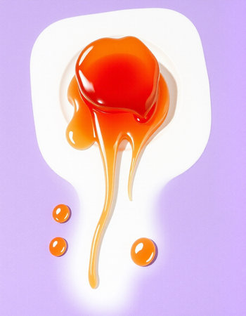 Sweet caramel sauce on a white plate isolated on a purple background.の写真素材