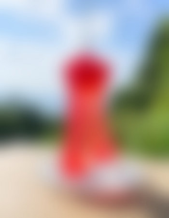 Blurred background of a red dress on the beach in summer.