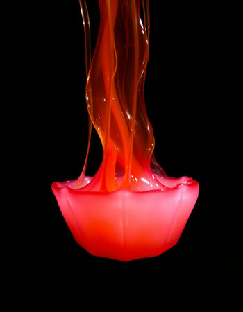 Colorful paint splashing isolated on black background. Studio shot.の写真素材