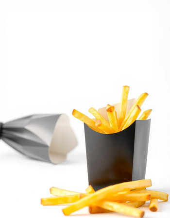 French fries in a black paper box isolated on a white background.の写真素材