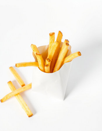 French fries in a white box on a white background. Selective focus.