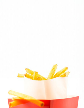 French fries in a paper bag on a white background. Copy space.の写真素材