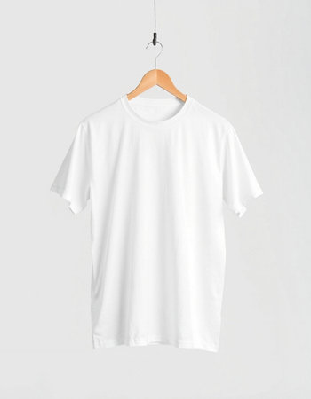 White t-shirt hanging on a wooden hanger isolated on white backgroundの写真素材