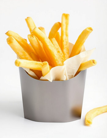 French fries in paper box on white background. Selective focus.