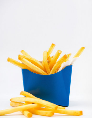 French fries in a blue box on a white background. Selective focus.の写真素材
