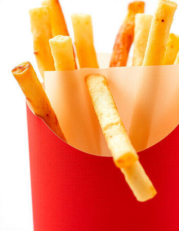 French fries in a red box on a white background, close-up