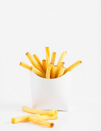 French fries in a white paper box on a white background. Fast food.の写真素材
