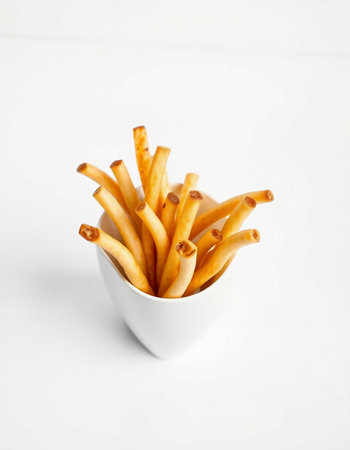 Crispy breadsticks in a white bowl on a white backgroundの写真素材