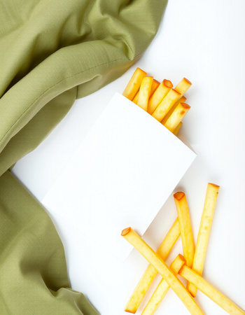 French fries with blank card and green cloth on white background, top viewの写真素材