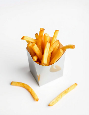 French fries in paper box on white background. Selective focus.