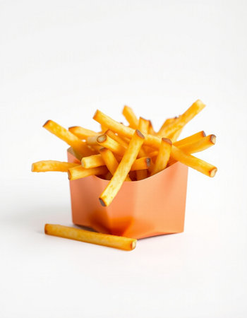 French fries in a paper box on a white background. Selective focus.