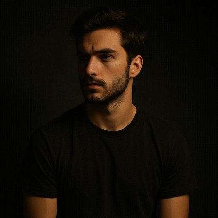 Portrait of a young man in a black t-shirt on a dark background