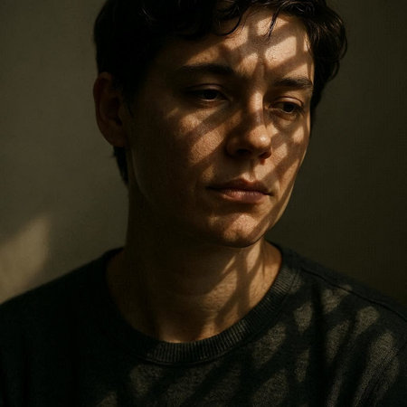 Portrait of a young man in a dark room with shadows.