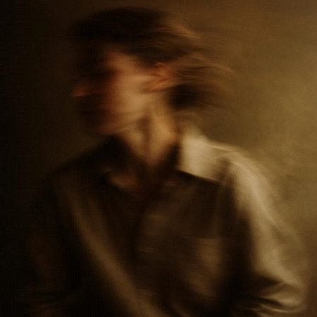 Portrait of a young man on a dark background. A long exposure.