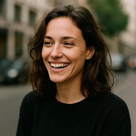 Portrait of a young smiling woman in a black sweater standing in the street.