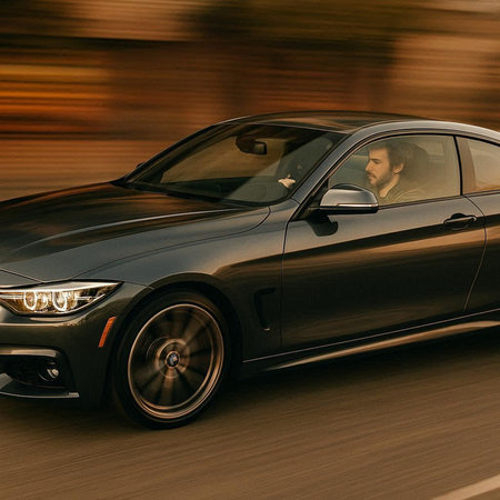 Car on the road with motion blur. Side view of a man driving a car.