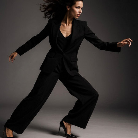 Fashion photo of young magnificent woman in black suit. Studio shot.