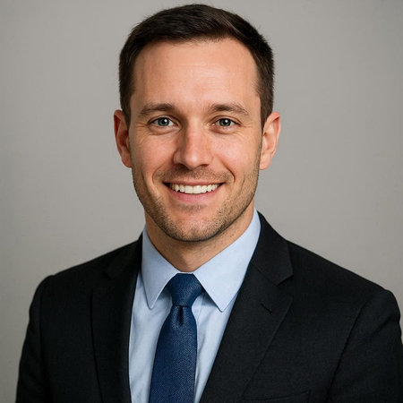 Portrait of a handsome business man smiling against gray background in studio