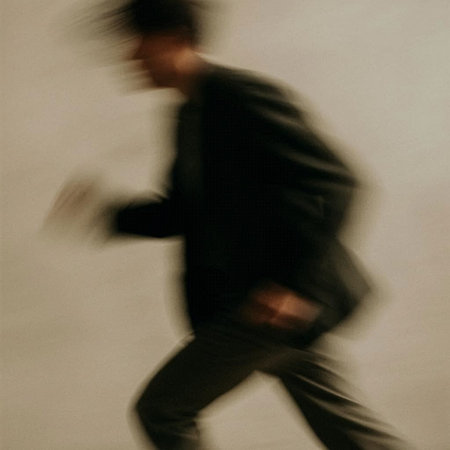 abstract image of a man in a black jacket running in motion