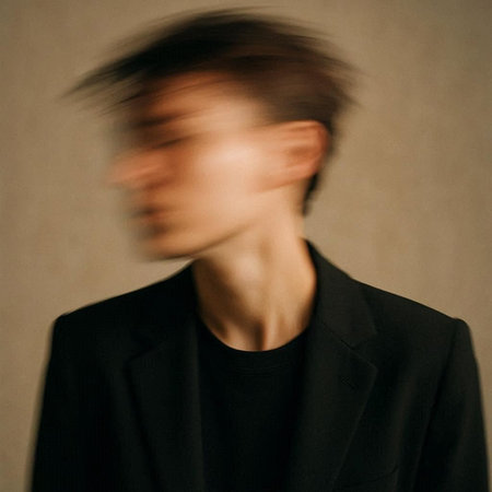 Portrait of a young man in a black coat. Studio shot.