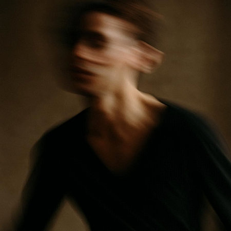 Portrait of a young man in a black T-shirt. Motion blur.