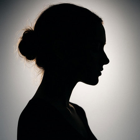Silhouette of a beautiful young woman on a gray background.の写真素材