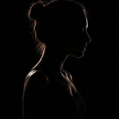 Silhouette of a beautiful young woman on a black background.の写真素材