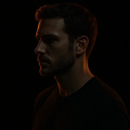 Portrait of a young man in a black T-shirt on a black background