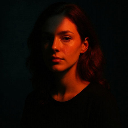 Portrait of a beautiful girl with red hair in a dark room