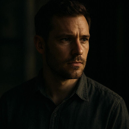 Portrait of a handsome serious man in a black shirt on a dark background