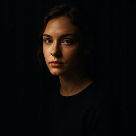 Portrait of a beautiful young woman in a black dress on a black background