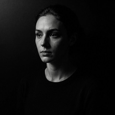Portrait of a young man in a black t-shirt on a dark background