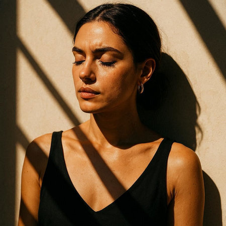 Portrait of a young woman with closed eyes on a light backgroundの写真素材