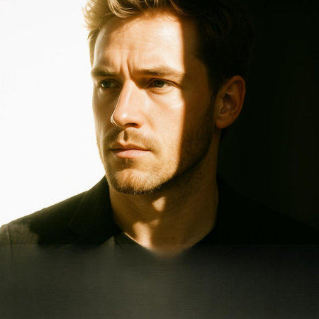 Portrait of a handsome young man on a dark background. Men's beauty, fashion.
