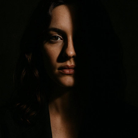 Portrait of a beautiful woman in a dark room. Studio shot.の写真素材