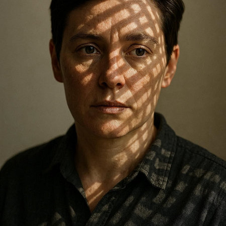 Portrait of a man with blinds on his face looking at the camera