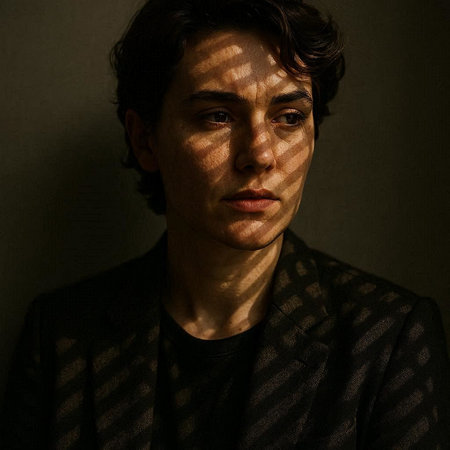 Portrait of a young man in a dark room with blinds