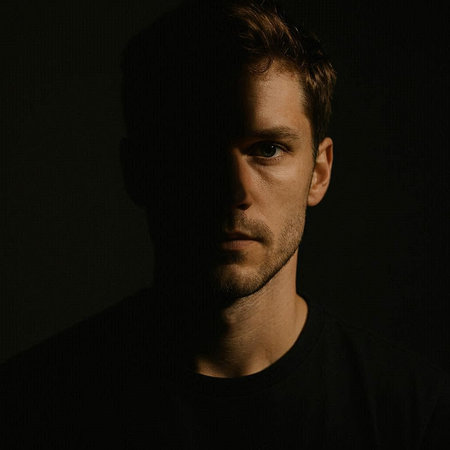 Portrait of a handsome young man with a beard on a dark background