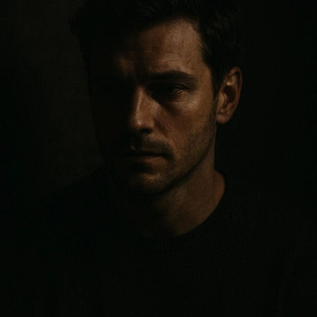 Portrait of a young man in a dark room. Studio shot.