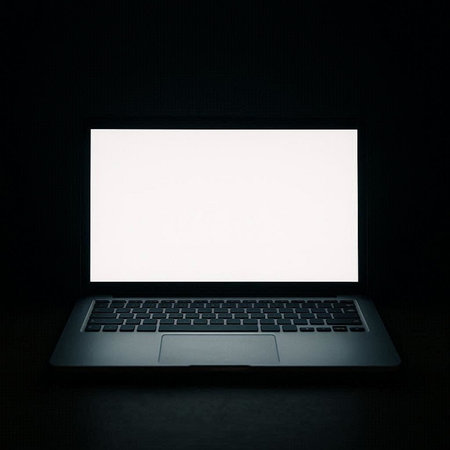 Laptop with blank white screen on black background. Mock up.の写真素材