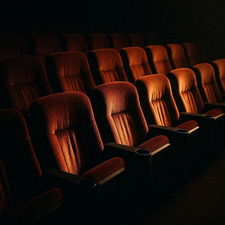 Cinema auditorium with rows of red seats in the darkの写真素材