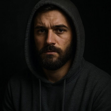 Portrait of a man with a beard in a hood on a black backgroundの写真素材